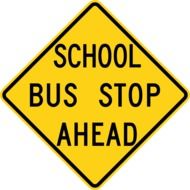 inscription "school bus stop ahead" on a yellow sign