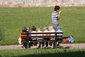 group of preschool children sitting on bench