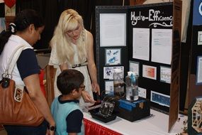 student with parents at a science fair