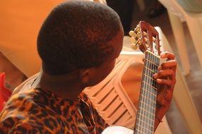 African man is learning guitar playing in the school of music