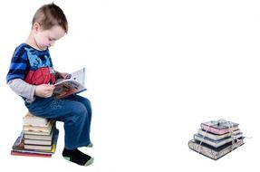 boy sitting on books and reading book