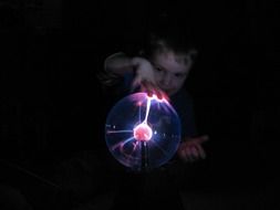 child near the plasma ball