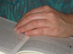 hand on an open book close up