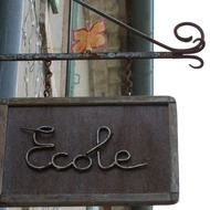metal sign ecole on the wall of the building