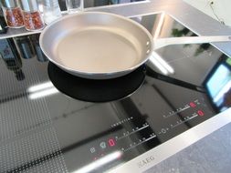 the frying pan stands on a high-tech stove