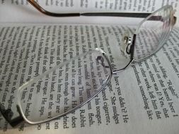glasses on an open book close-up
