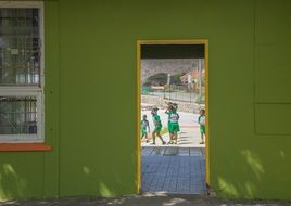 team of students on sports ground, view through school doorway, curacao