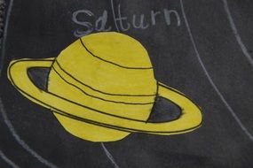 saturn made by child on a blackboard