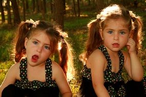 twin sisters with blue eyes in identical dresses