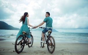 loving couple on bikes on the beach