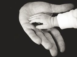 the palm of a small child on the palm of an old man