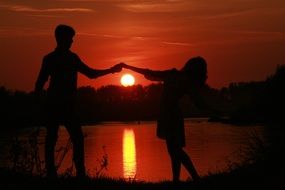 loving couple and sunset reflected in water