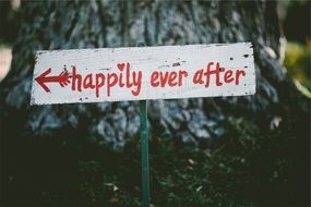 a sign with an inscription near the tree