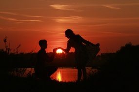 shade of the loving couple near the water in the evening