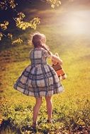 little girl in a plaid dress in nature