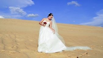 bride in a wedding dress in the sand dunes