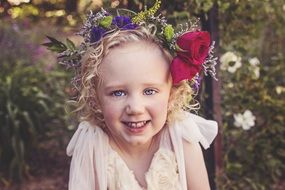 portrait of a happy little girl in a wreath