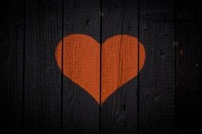 Red heart on wooden black wall