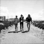 three people walk along a wide path