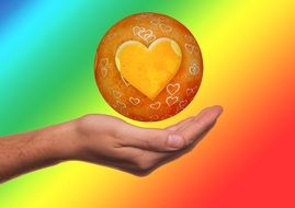 orange heart in a circle above a hand