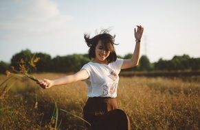 smiling girl among the field on a windy day