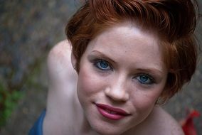 beautiful red-haired girl with blue eyes close up