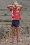 the child covers his face with his hands