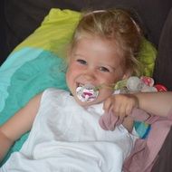 Little girl with a pacifier smiling