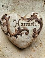 stone carved in the shape of a heart with the inscription "armony"