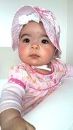 little girl in a pink dress and panama