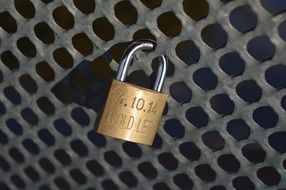 golden pad lock on metal railing