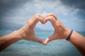 heart of hands on the background of the sea