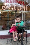 cute small girl and boy at sweet tooth candy shop