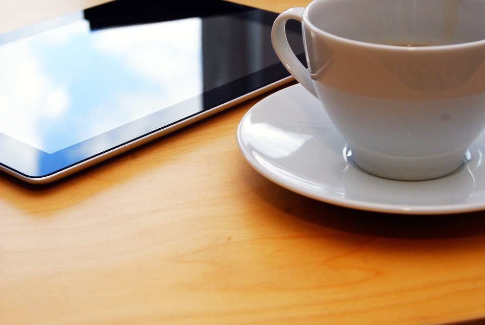a cup of coffee in the office on the background of the smartphone
