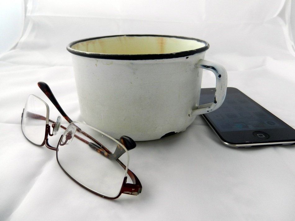 grunge mug, glasses and phone at white background