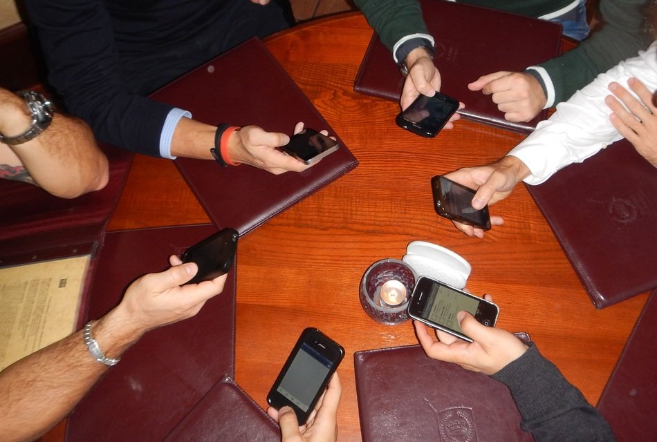 people with smartphones at the round table