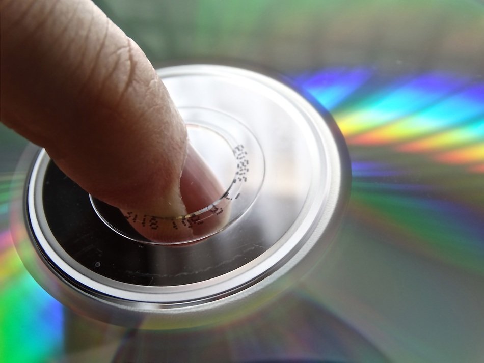 macro photo of finger in center of compact disk