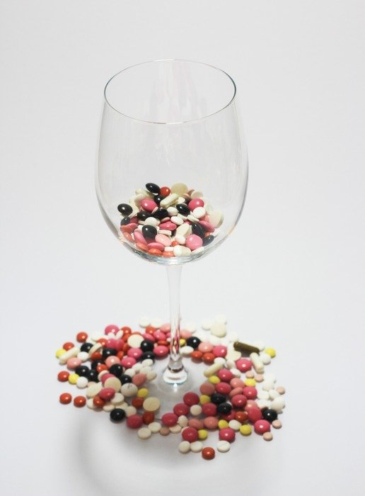 Colored tablets in a glass and around