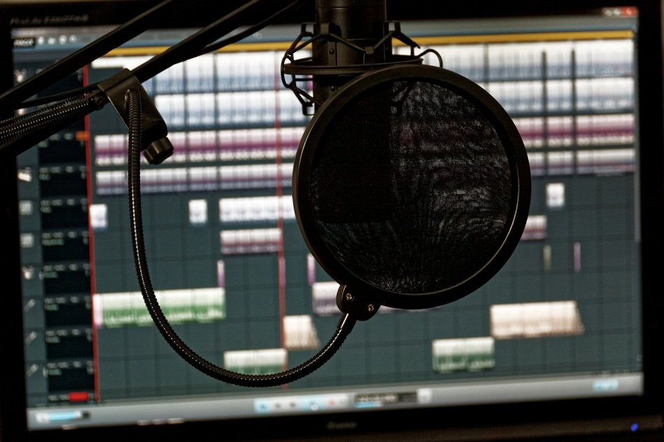 Microphone in sound studio on a background of a laptop with the software