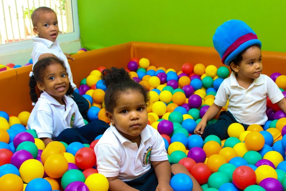 small children in the pool with balls