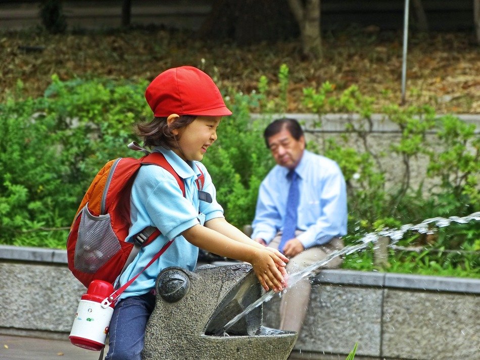 girl near a fountain in a park in japan