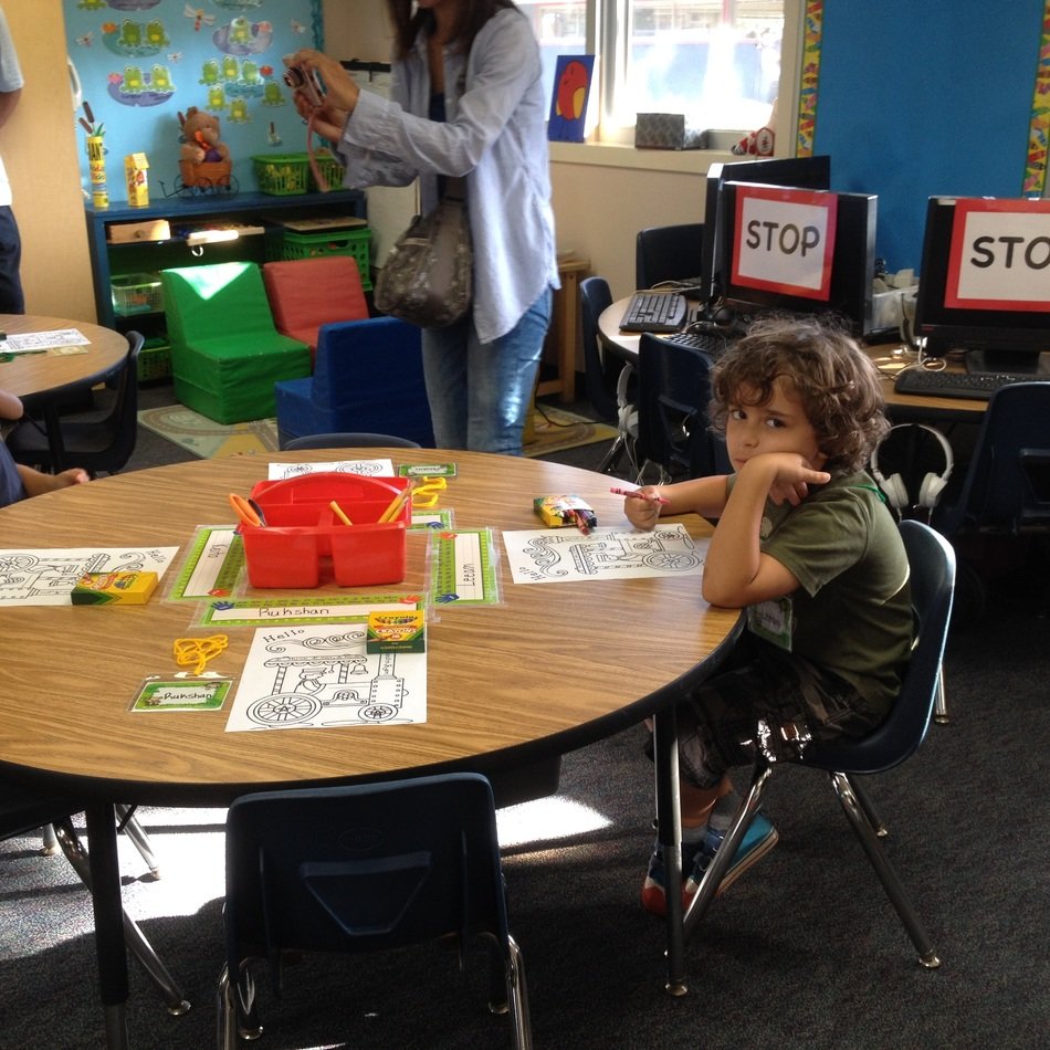 child at a table in a school class
