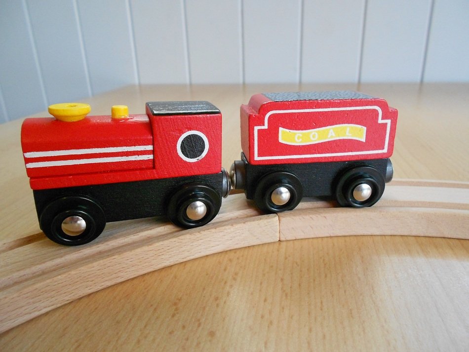 children's wooden red train on wooden rails