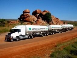 Big white trucks near the rocks