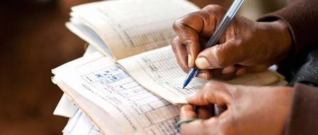 man writes with pen on a piece of paper