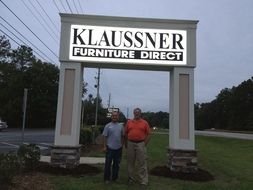 people stand near an outdoor sign