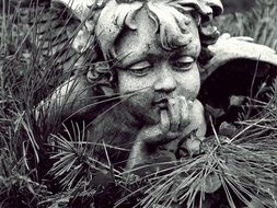 sculpture of a angel among conifer needles