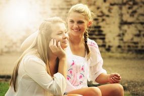 two pretty young girls smiling under the light