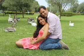 happy asian couple in love among geese in park