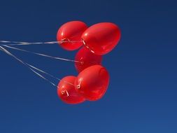 five red balloons on a sky